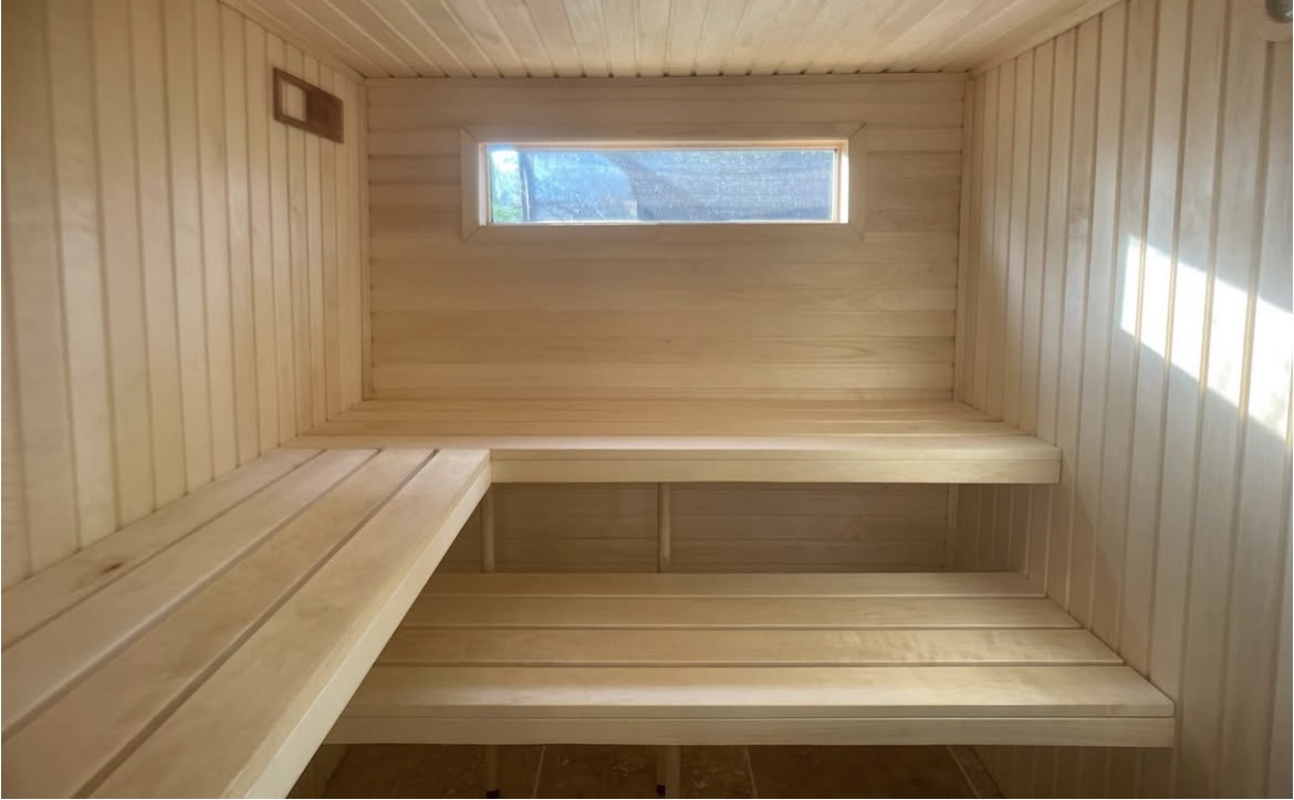 Interior of the Forma sauna showing aspen wood benches and natural light