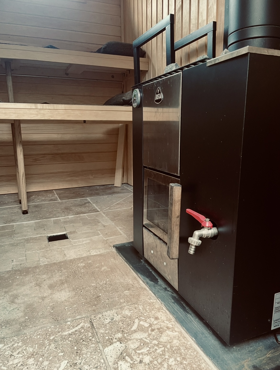 Travertine stone floor and timber detailing inside the Forma wood-fired sauna