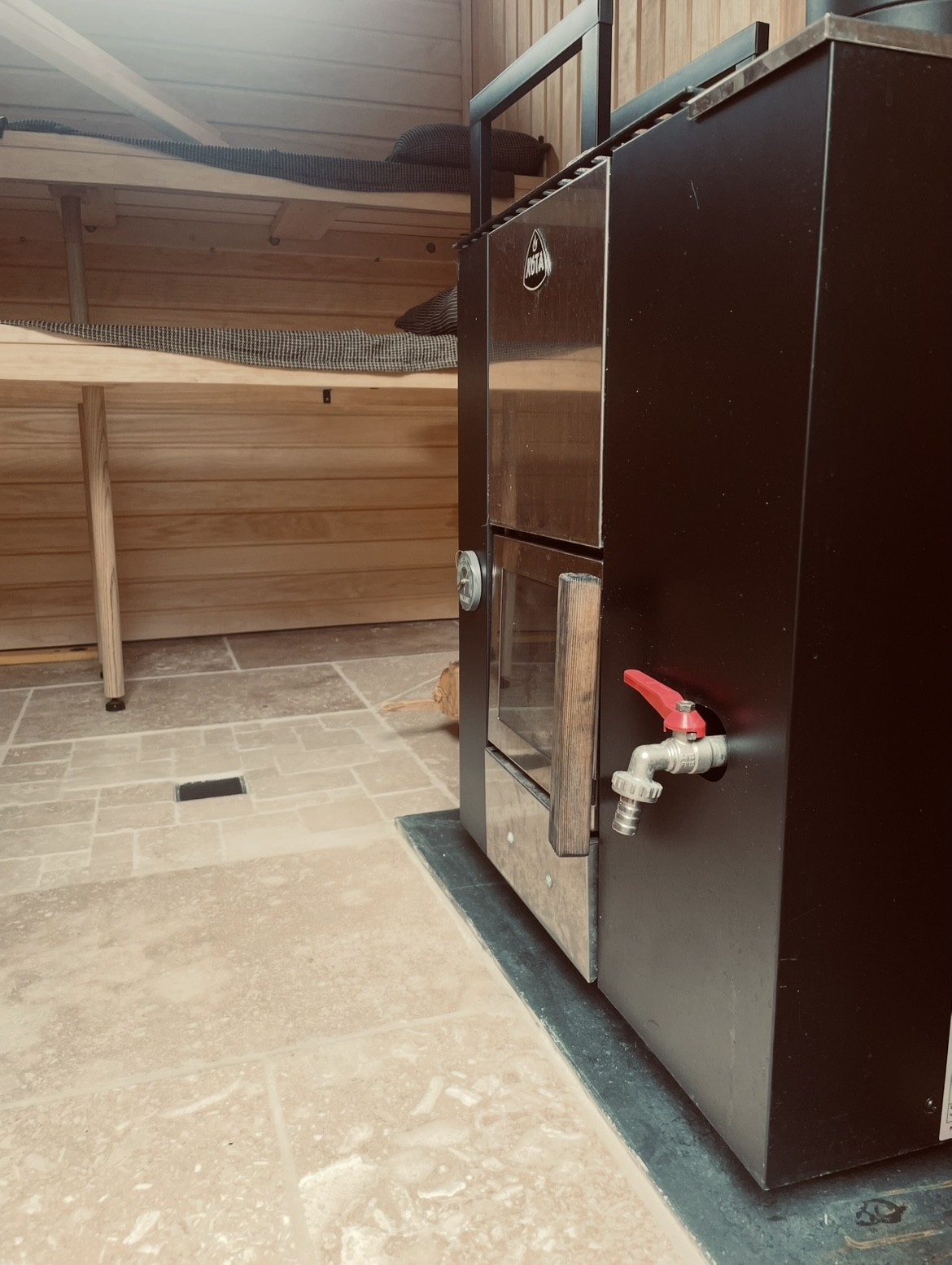 Travertine stone floor and timber detailing inside the Forma wood-fired sauna